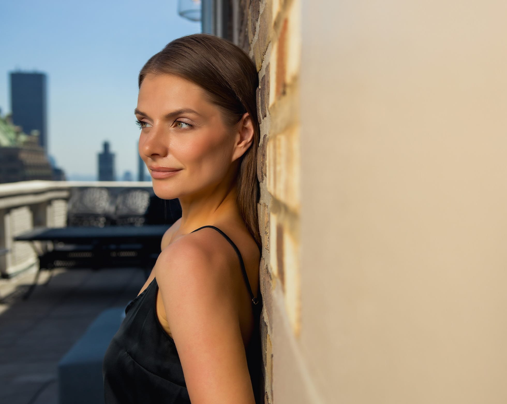Woman smiling leaning against the wall