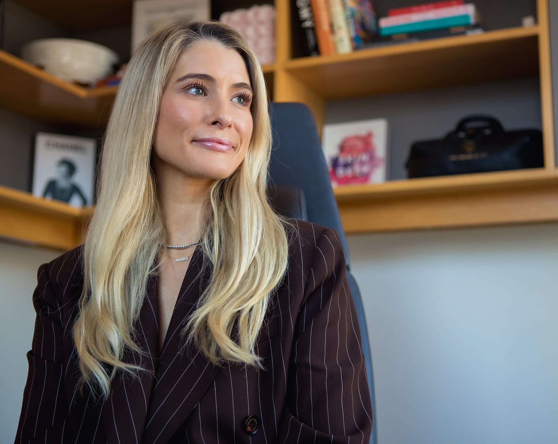 woman with blonde hair wearing a pinstripe suit jacket